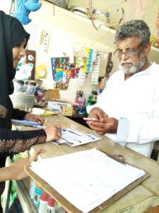 Student Activist helping a Shop Owner to Download GHMC App